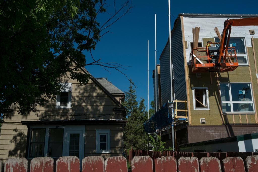 A new apartment complex being built next to a single-family home in South Minneapolis