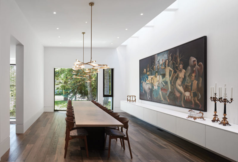  Dining room is illuminated by a linear skylight along its length and can be opened up into the kitchen by a series of pivoting doors to allow it to seat up to 30 people