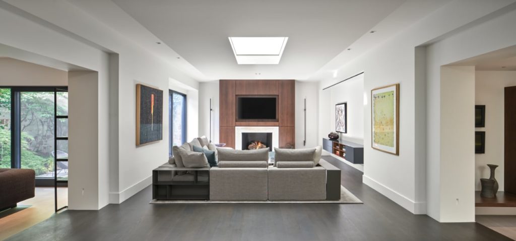 Contemporary light-filled interior that incorporates a rich material palette of wood, stone, bronze and leather