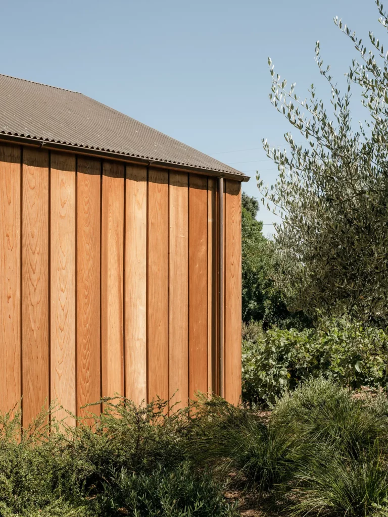 Local heritage is honored through the use of locally harvested redwood siding, adding to the barn's rustic charm.